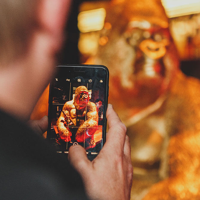 Gast macht ein Handyfoto vom goldenen Gorilla im THE NEW GRACE