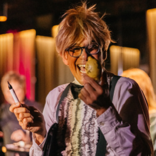 Entertainer freut sich über Zitrone, die er in die Kamera hält, welche ihm Peter Freudenthaler unterschrieben hat.